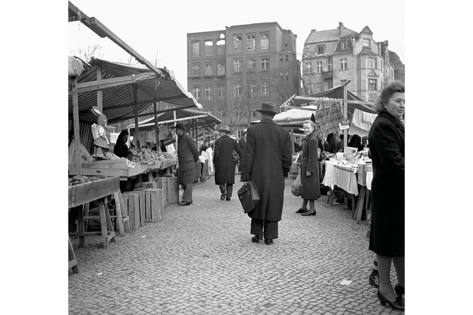 A weekly market was held amid bombed buildings after world war two. © ullstein Bild ‒ archive/Weissberg